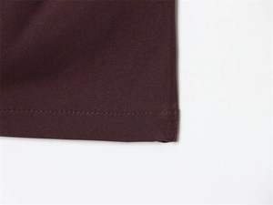 Detail of deep brown dress fabric with professional single-needle stitching and clean hem