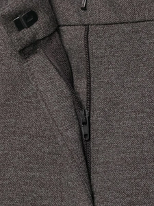 Detail of dark brown trousers waist featuring high-quality metal zipper and hook closure