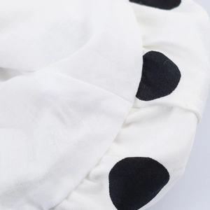 Macro shot of white fabric with black polka dots showing detailed woven texture on summer top