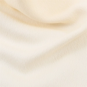 Vue macro détaillée du tissu textile crème avec une texture de drapé doux et élégant