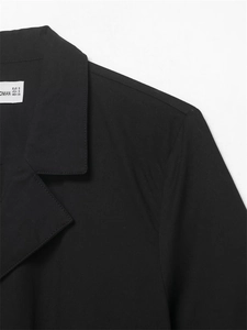 Détail du col en popeline noire et de l'étiquette de taille d'une robe minimaliste