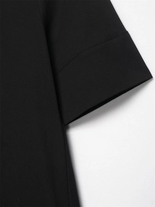 Gros plan détaillé montrant la double couture précise sur l'ourlet d'une robe noire en popeline