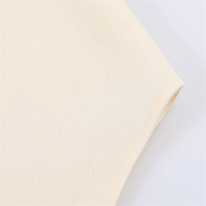 Gros plan sur la texture du tissu beige avec coutures précises et finitions soignées