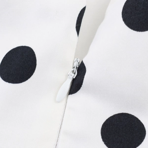 Detail of white hidden zipper on polka dot print fabric with diagonal twill texture
