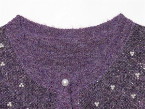 Detailed macro view of purple mohair cardigan with pearl clusters and sequin accents