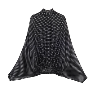 Detailed view of the black and white polka dot mock neck blouse with batwing sleeves