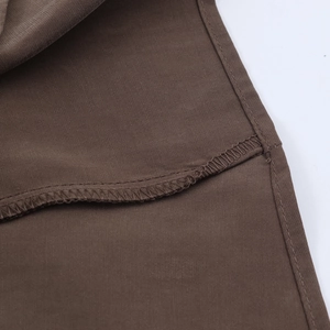 Dettaglio macro dell'abito estivo marrone con cuciture piatte e rifiniture overlock