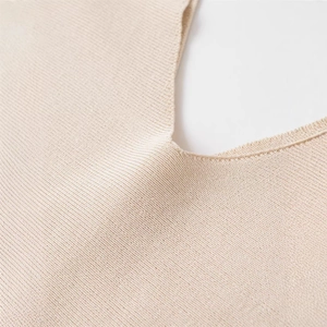 Chic beige V-neck knitted sweater featuring fine ribbed texture and soft craftsmanship