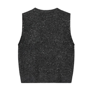 Macro detail of dark grey knit vest with silver sequins and ribbed hemline finish