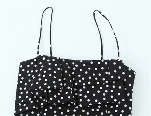 Detailaufnahme des schwarz-weißen Polka-Dot-Minikleids mit Volant-Details und schmalen Trägern