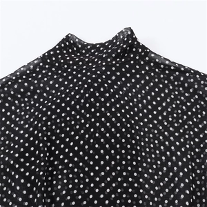 Close-up of mock neck collar on a black and white polka dot chiffon blouse