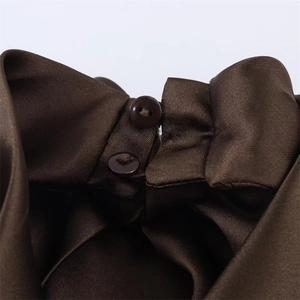 Detail view of smooth chocolate satin fabric with two round buttons on the collar