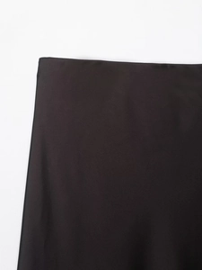 Detalle de la cintura elástica y el tejido de satén negro sedoso de esta falda midi
