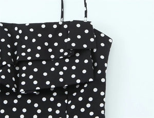 Detail eines schwarzen Polka-Dot-Minikleids mit gestuften Rüschen und schmalen Trägern