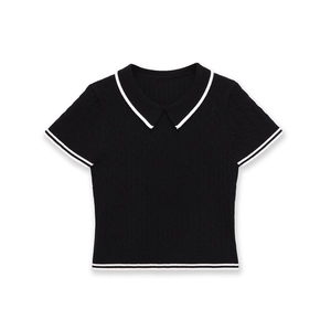 Détail de la maille torsadée noire avec rayures blanches contrastées au col et aux manches