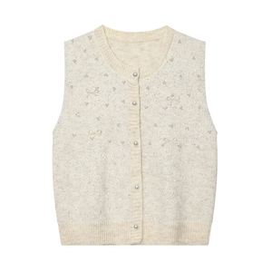 Detail of beige knit vest with pearl buttons and sparkling bow-shaped sequin embroidery