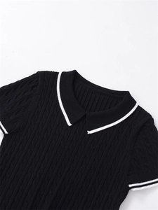 Gros plan sur un pull noir en maille torsadée avec col POLO et bordure blanche