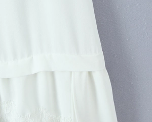 Detailed close-up of white summer dress featuring elegant eyelash lace trim and chiffon fabric