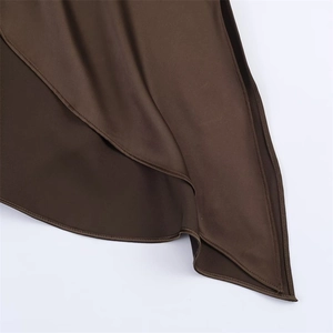 Detail of dark brown silk dress showing smooth fabric texture and precise hem stitching