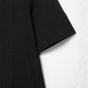 Gros plan d'une manche de robe en popeline noire avec coutures précises et détails aux poignets