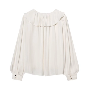 Close-up of golden cylinder buttons on cream puff sleeves and ruffled collar texture