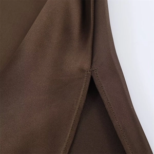 Detail of the high-slit hem on a dark brown satin dress with professional stitching