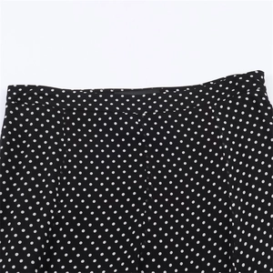 Close-up of waistline detail on black and white polka dot skirt with fine stitching