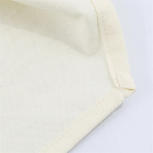 Close-up of high-quality pleated stitching and edge sewing details on cream tube top