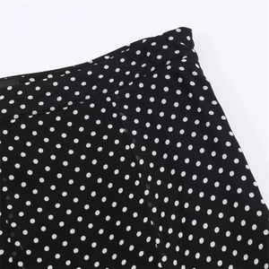 Detailed close-up of the high-quality stitching and white polka dot pattern on black fabric