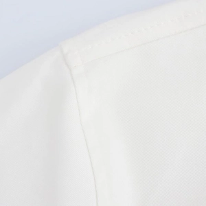 Close-up of precise single-needle stitching on high-density white twill fabric detail
