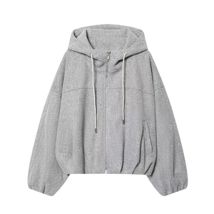 Detail view of grey hooded zip-up sweatshirt with textured fleece fabric and silver zipper