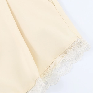 Vue détaillée de l'ourlet du short en satin beige avec dentelle délicate