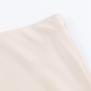 Detailed close-up of neat stitching and smooth satin texture on the beige midi skirt hem