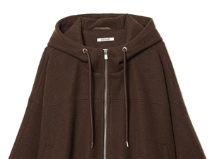 Detail of dark brown hooded jacket featuring silver zipper and textured wool fabric