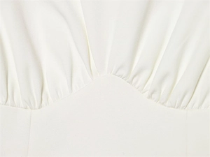 Gros plan du détail en tissu plissé blanc élégant avec couture fine et texture douce