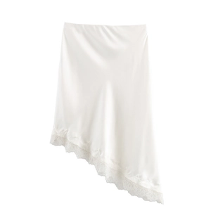 Detail of white satin skirt featuring asymmetrical hem and delicate eyelash lace trim