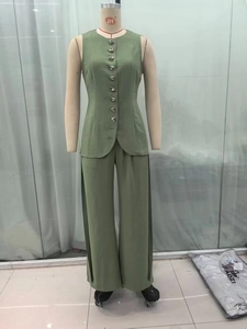 Detail of moss green two-piece set featuring silver triangle buttons and wide-leg trousers