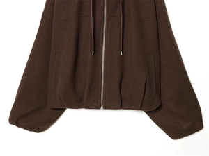 Detailed shot of dark brown hoodie jacket with silver zipper and elastic cuffs