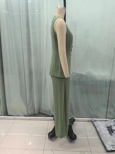 Detail view of sage green two-piece set featuring a side-button vest and wide-leg trousers