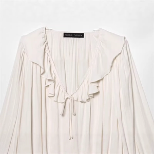Women's cream v-neck blouse featuring layered ruffles and textured drawstring details