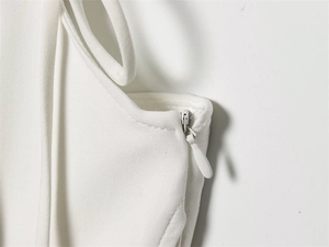 Dettaglio della cerniera invisibile di alta qualità su abito bianco a corsetto