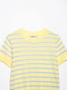 Détail du haut en tricot à rayures jaunes et bleues montrant le col rond et la texture