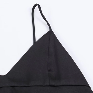 Detailed macro view of the black satin fabric and fine stitching on the camisole top