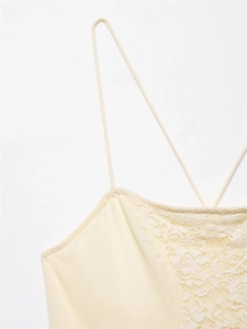 Detailed macro view of cream lace patchwork and criss-cross thin straps on a slim summer dress