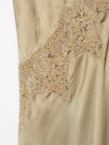 Macro view of champagne satin fabric with delicate lace embroidery and floral patterns