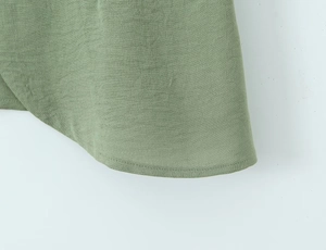 Close-up of olive green cotton-linen blend fabric texture and fine hem stitching