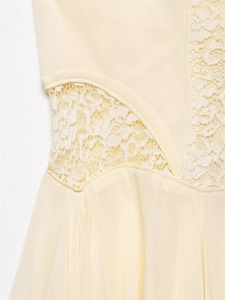 Detailed view of cream dress featuring elegant floral lace patchwork and waist contouring