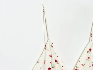 Detailed close-up of cream camisole with red rose floral print and slim shoulder straps