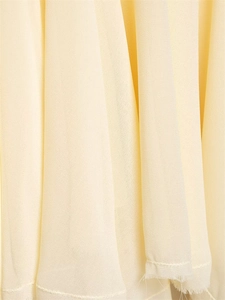 Macro shot of light yellow chiffon fabric with rolled hem stitching and soft texture