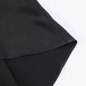 Detail of the high-quality stitching and smooth satin fabric on the black camisole top